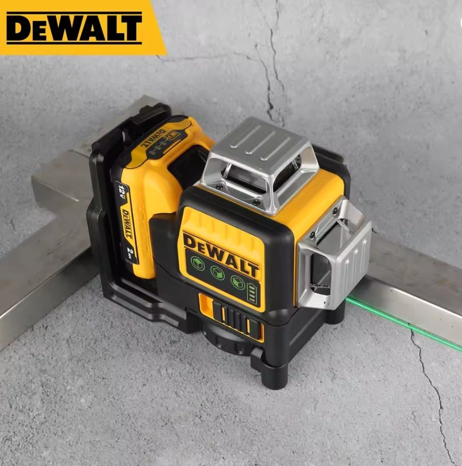 Grüner Kreuzlinienlaser DEWALT DW089LG auf einem Betonsockel mit einem klaren Laserstrahl.