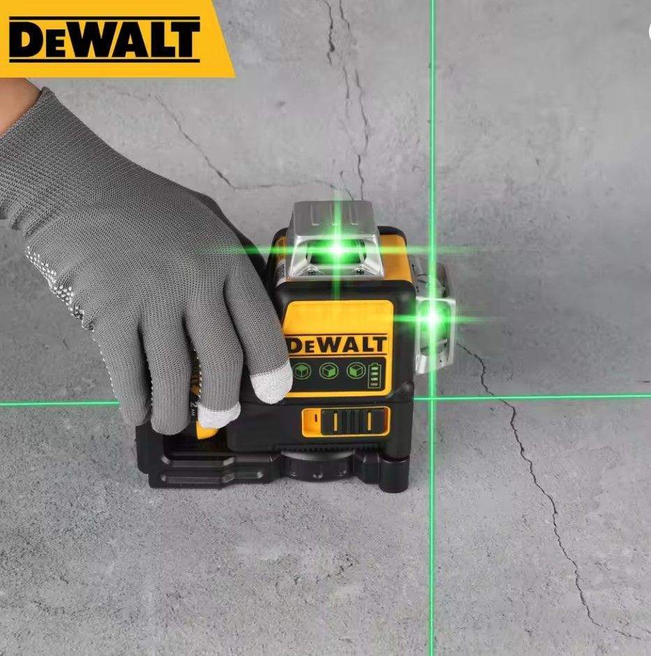 Grüner Kreuzlinienlaser DEWALT DW089LG mit einer handgeführten Verwendung und sichtbaren grünen Linien auf der Oberfläche.